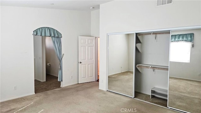 unfurnished bedroom featuring a closet, carpet flooring, and visible vents