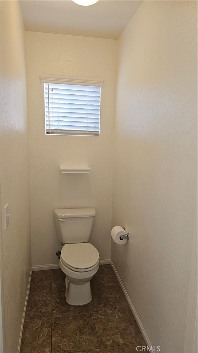 bathroom with toilet and baseboards