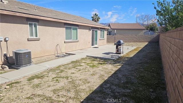 exterior space featuring a fenced backyard, a patio area, and cooling unit