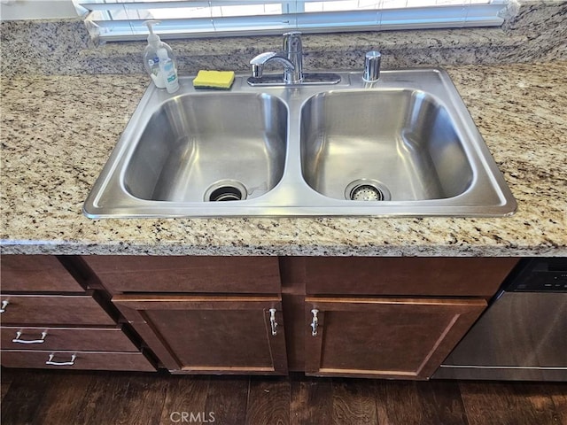 interior details featuring dark wood finished floors, light countertops, a sink, dark brown cabinetry, and dishwasher