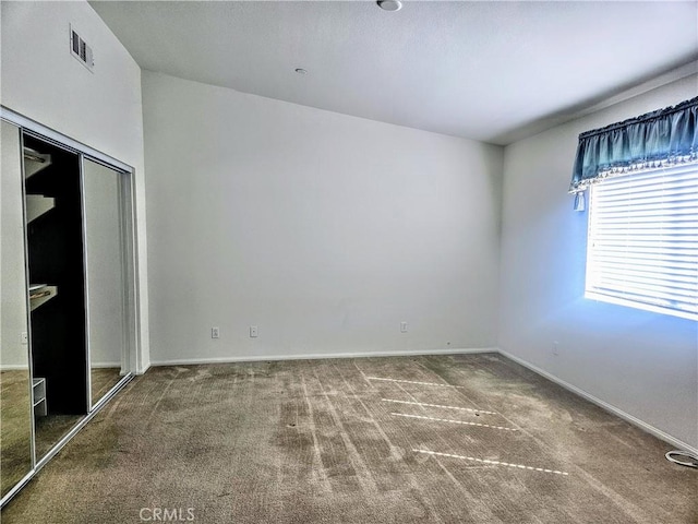 unfurnished bedroom featuring a closet, carpet, visible vents, and baseboards