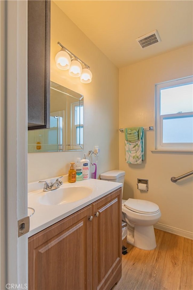 bathroom featuring toilet, hardwood / wood-style flooring, and vanity