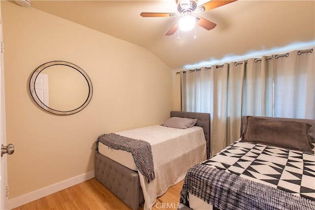 bedroom featuring ceiling fan, light wood-type flooring, and lofted ceiling