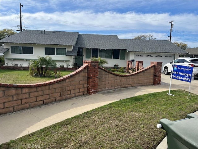 ranch-style house featuring a front yard and a garage