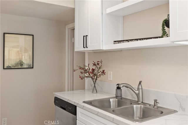 kitchen featuring light stone counters, white cabinets, dishwasher, and a sink