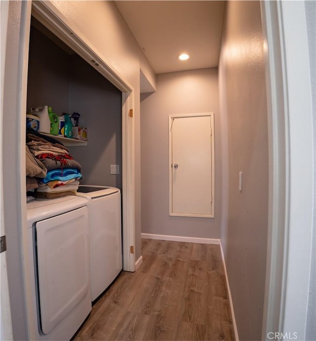 clothes washing area with light wood-type flooring and washing machine and dryer