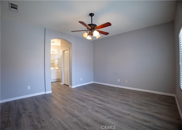 empty room featuring dark wood-type flooring and ceiling fan