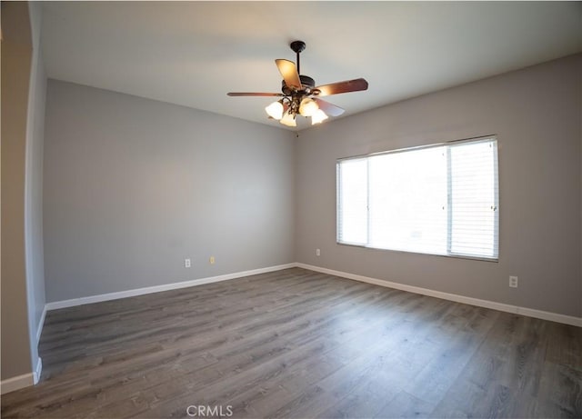 empty room with dark hardwood / wood-style flooring and ceiling fan