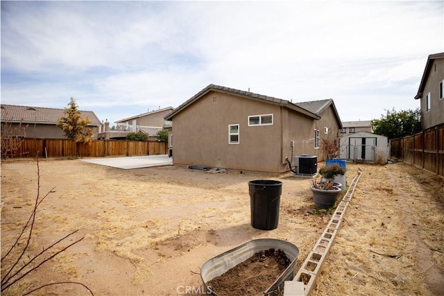 back of house with a patio area, a storage unit, and central AC unit