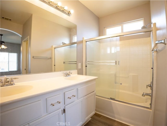 bathroom featuring hardwood / wood-style flooring, combined bath / shower with glass door, and vanity