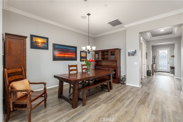 dining space with a chandelier, light wood finished floors, and baseboards