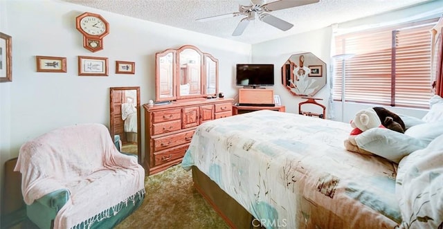 carpeted bedroom featuring ceiling fan and a textured ceiling