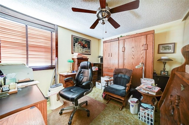 office area with ceiling fan, carpet flooring, and a textured ceiling