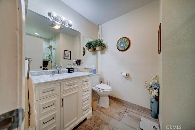 bathroom featuring vanity, wood-type flooring, a shower, and toilet