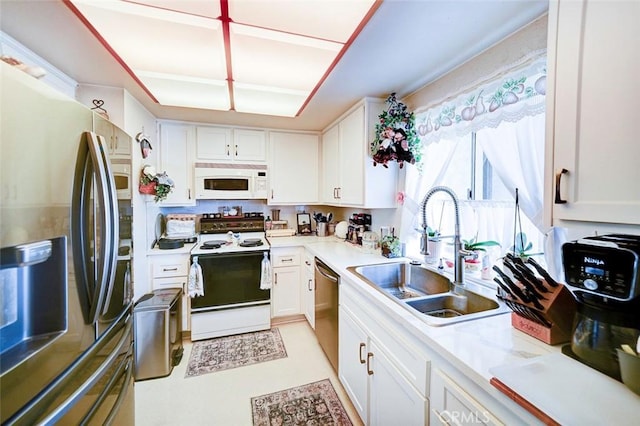 kitchen with appliances with stainless steel finishes, sink, and white cabinets