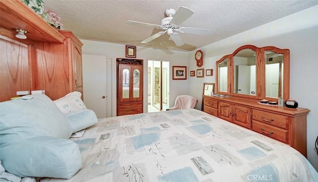 bedroom featuring ceiling fan and a textured ceiling