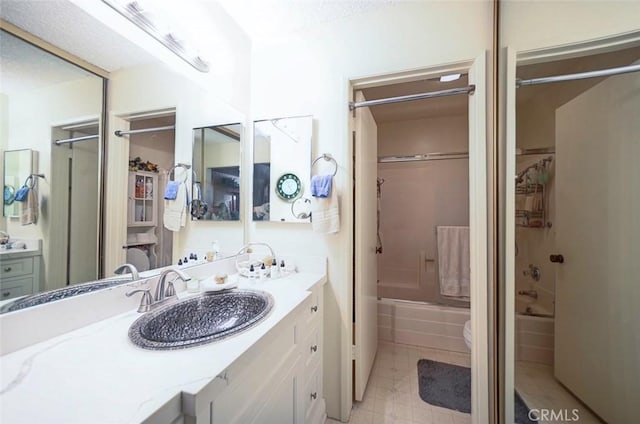 full bathroom featuring vanity, enclosed tub / shower combo, and toilet