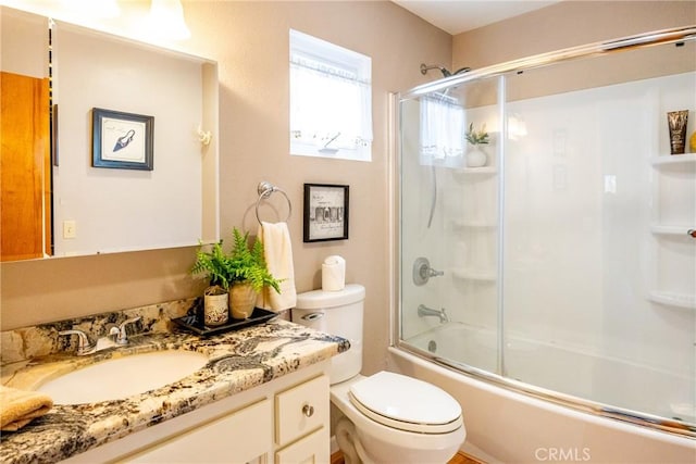 full bathroom with vanity, toilet, and bath / shower combo with glass door