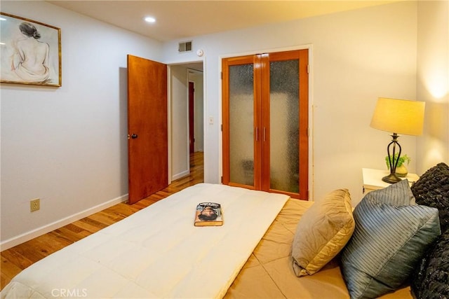 bedroom featuring hardwood / wood-style flooring and french doors