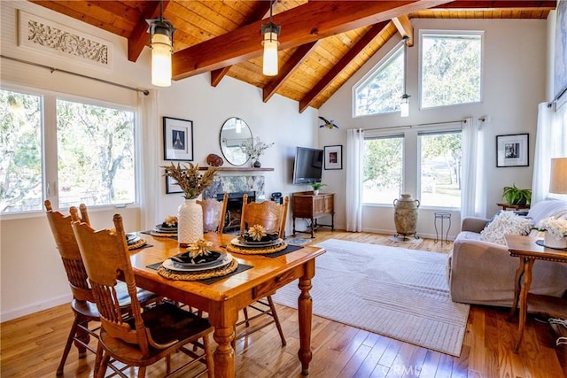 dining area with wood ceiling, a high end fireplace, plenty of natural light, and light wood-type flooring