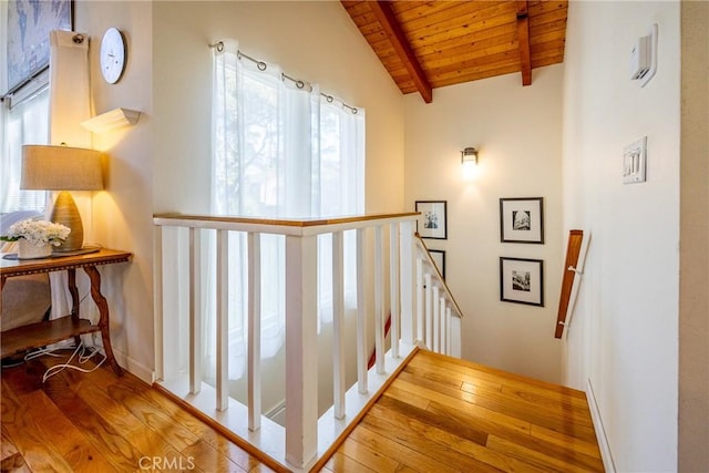 stairway with wood ceiling, lofted ceiling with beams, and hardwood / wood-style floors