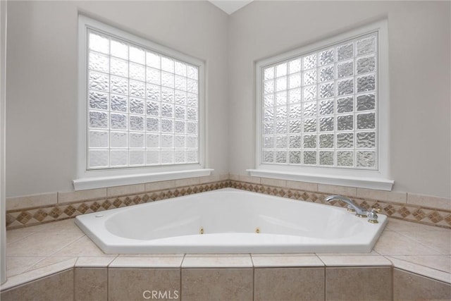 bathroom featuring tiled tub and plenty of natural light