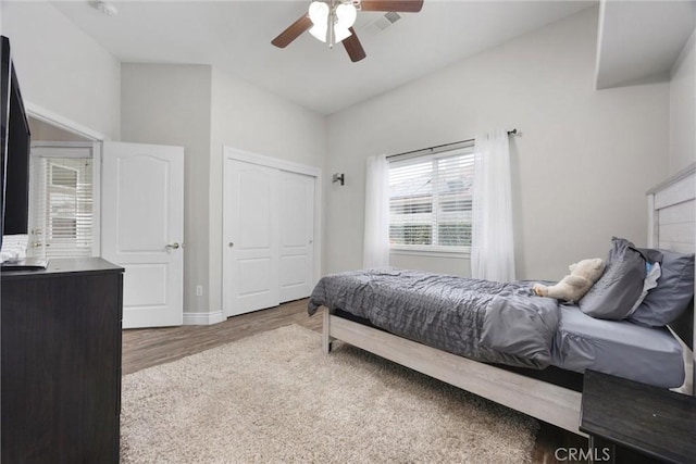 bedroom with hardwood / wood-style flooring, ceiling fan, and a closet