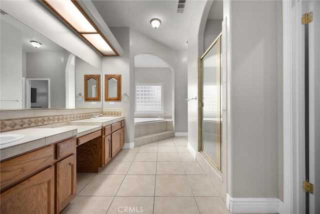 bathroom featuring tile patterned flooring, vanity, independent shower and bath, and decorative backsplash