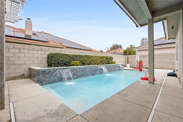 view of swimming pool with pool water feature and a patio area