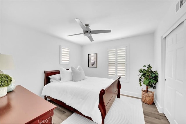 bedroom with light wood-type flooring, a closet, and ceiling fan