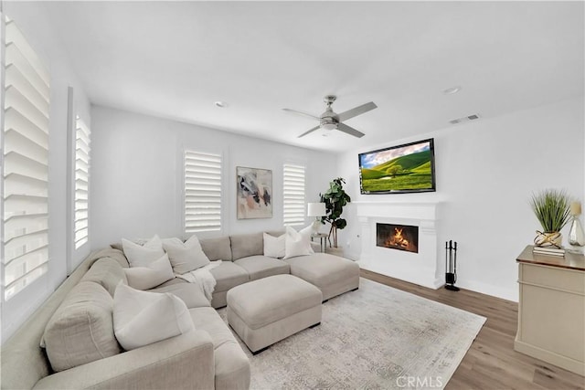 living room featuring ceiling fan and light hardwood / wood-style floors