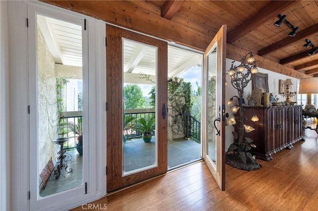 doorway featuring beam ceiling, wood ceiling, and wood-type flooring