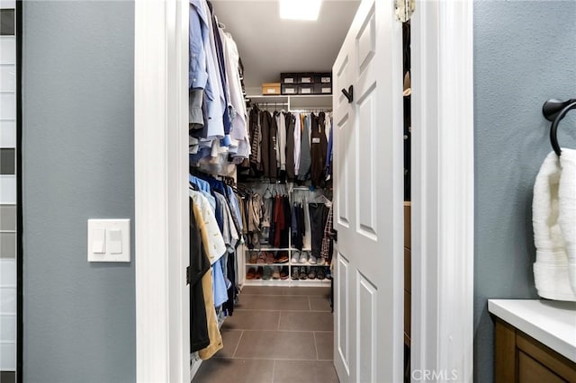 walk in closet with dark tile patterned flooring