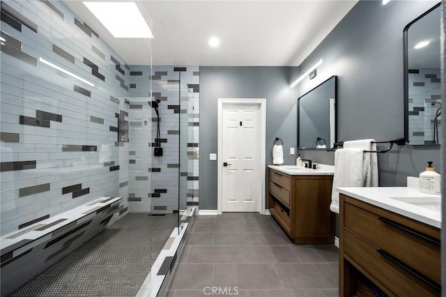 bathroom with vanity, tile patterned flooring, and a tile shower