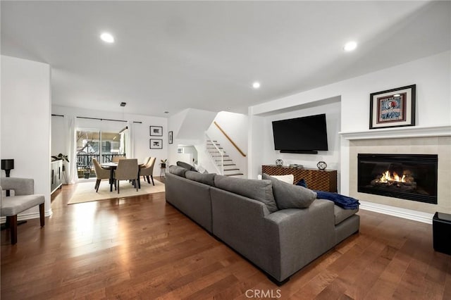 living room with dark wood-type flooring and a tile fireplace