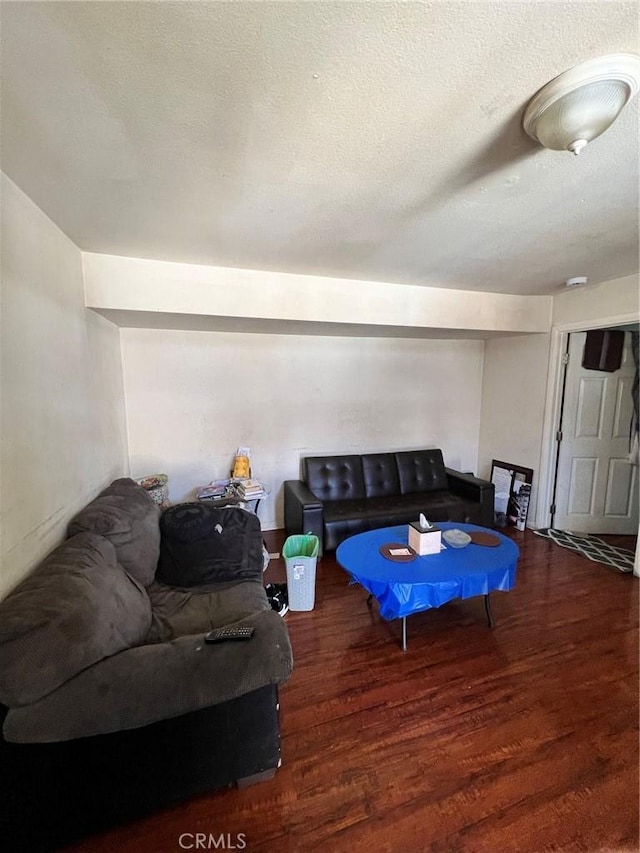 living room featuring dark hardwood / wood-style floors and a textured ceiling