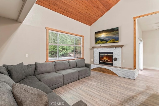 living room featuring a brick fireplace, light hardwood / wood-style flooring, wooden ceiling, and high vaulted ceiling