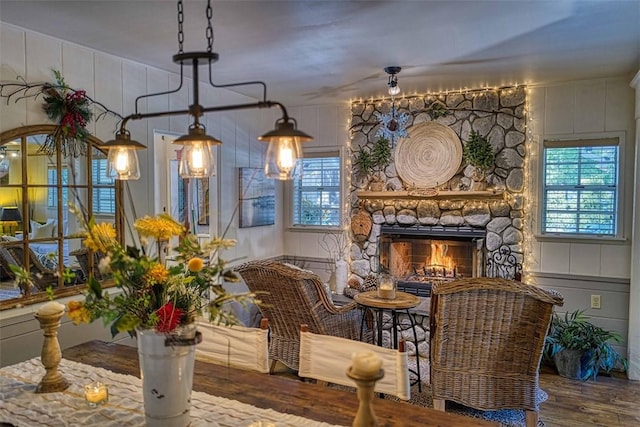 living area featuring a stone fireplace and wood-type flooring