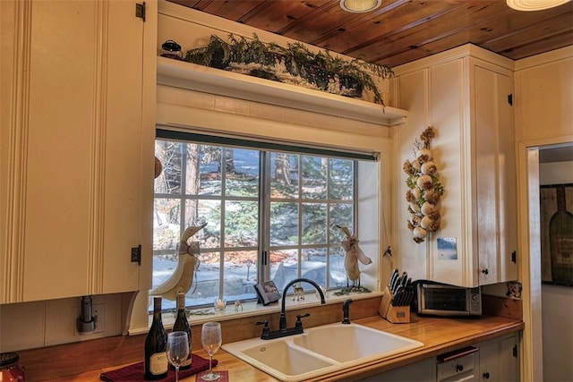 kitchen featuring white cabinetry, sink, wooden counters, and wood ceiling