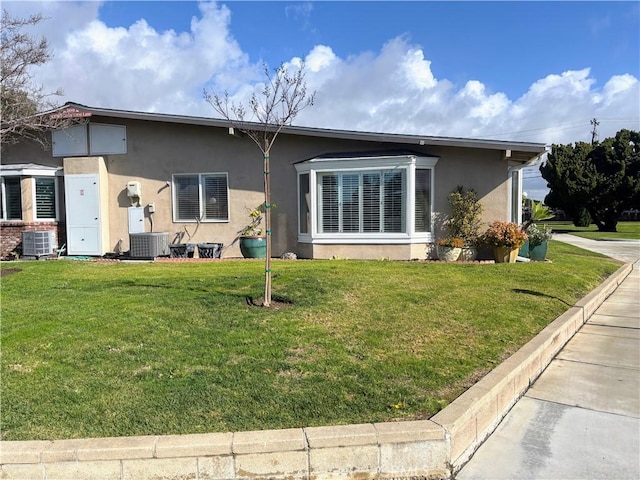 view of front of home featuring cooling unit and a front lawn