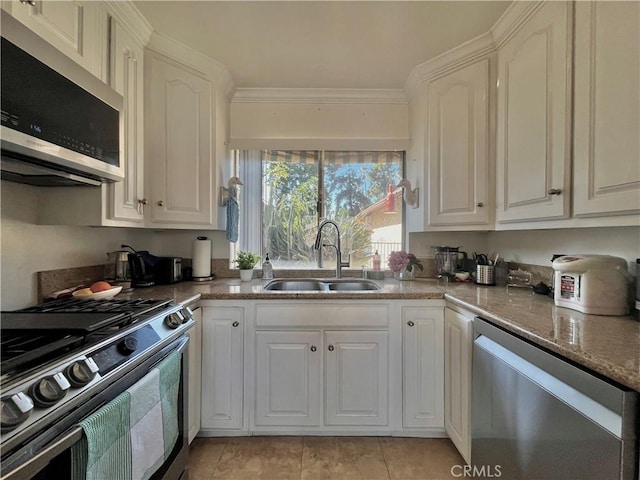 kitchen featuring stone counters, appliances with stainless steel finishes, sink, white cabinets, and ornamental molding