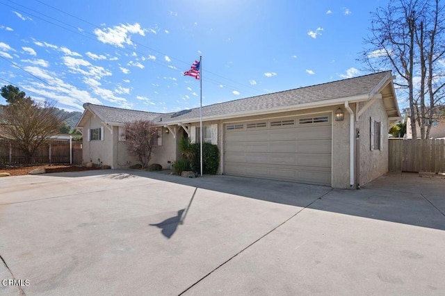 single story home with concrete driveway, an attached garage, fence, and stucco siding