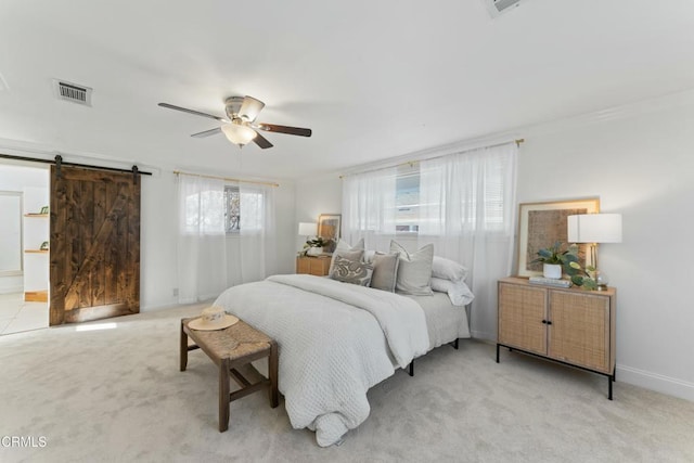 bedroom with visible vents, a barn door, carpet flooring, ceiling fan, and baseboards