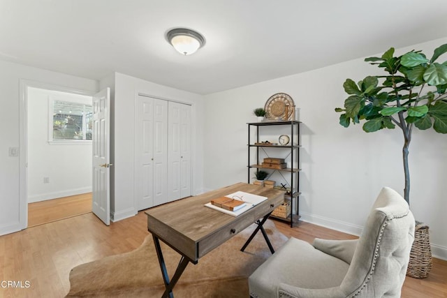 home office featuring light wood-type flooring and baseboards