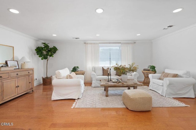 living room with light wood-style floors, visible vents, ornamental molding, and recessed lighting