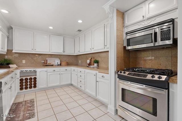 kitchen featuring white cabinetry, visible vents, stainless steel appliances, and backsplash