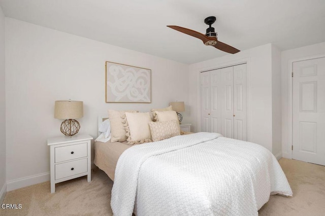 bedroom with light carpet, a closet, a ceiling fan, and baseboards