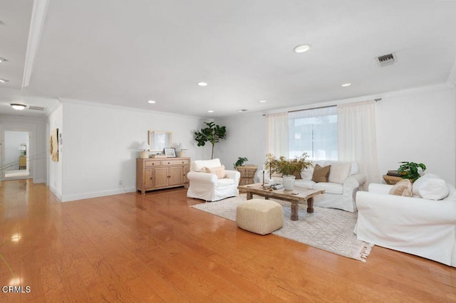 living area with recessed lighting, visible vents, crown molding, and light wood finished floors