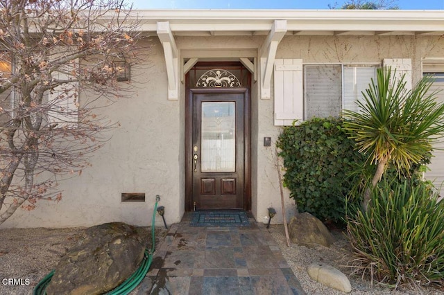 view of exterior entry featuring crawl space and stucco siding