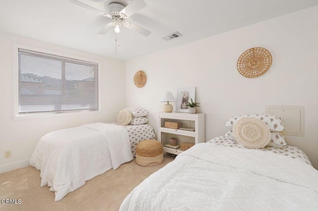 carpeted bedroom featuring a ceiling fan, visible vents, and baseboards